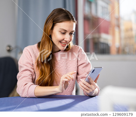 Young woman is texting with someone on a mobile phone Young woman is texting with someone on a mobile phone 129609179