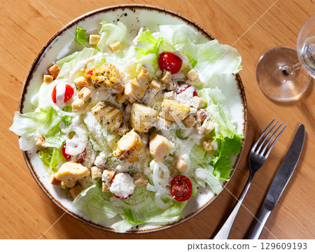 Variation of Caesar salad with chicken, lettuce mix and crackers Variation of Caesar salad with chicken, lettuce mix and crackers 129609193