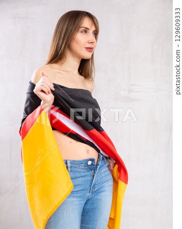 Young woman wrapped in Germany flag 129609333