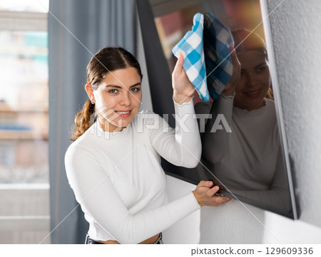 Woman washing TV monitor during cleanup Woman washing TV monitor during cleanup 129609336