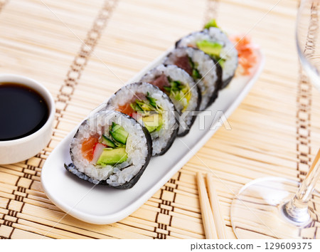 Set of japanese rolls futomaki with soy and chili sauces close up 129609375