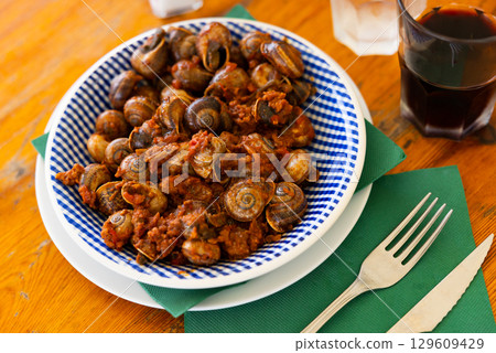 Snails with minced meat and tomatoes. Mediterranean dish 129609429