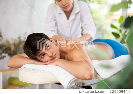 Young man enjoying therapeutic back massage 129609444