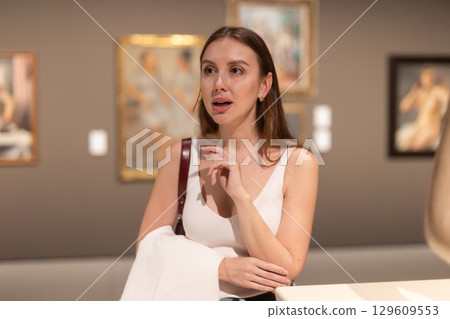 Girl view pictures and icons in museum hall 129609553