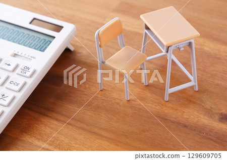 School desks, chairs, and calculators give an image of education costs that continue to rise and put pressure on household budgets. 129609705