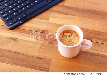 坐在辦公桌前用筆記型電腦工作,同時喝著現煮的美味咖啡的圖片 坐在辦公桌前用筆記型電腦工作,同時喝著現煮的美味咖啡的圖片 129609976