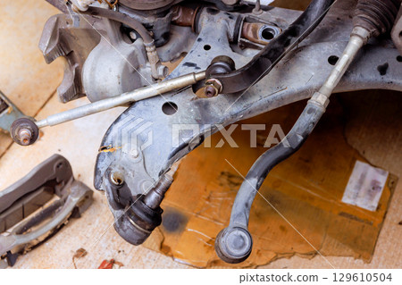 Mechanics repair suspension components in garage with various tools parts Mechanics repair suspension components in garage with various tools parts 129610504