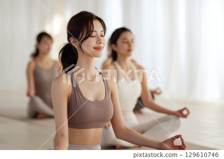 Young Japanese people meditating and refreshing in group yoga 129610746