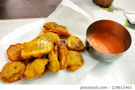 Banana Fritters Served with Spicy Red Chutney Banana Fritters Served with Spicy Red Chutney 129611463