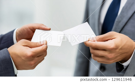 商務禮儀的時刻，兩個穿著西裝的人禮貌地交換名片，正式的背景 129611946