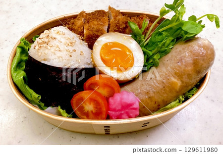 A traditional Korean dosirak, beautifully arranged with rice, assorted banchan, and savory proteins. Balanced and visually inviting, its a portable meal packed with vibrant flavors. 129611980