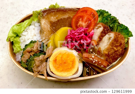 A traditional Korean dosirak, beautifully arranged with rice, assorted banchan, and savory proteins. Balanced and visually inviting, its a portable meal packed with vibrant flavors. 129611999