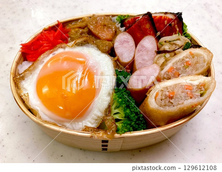 A colorful dosirak lunchbox filled with neatly arranged rice, savory protein, and assorted side dishes. A portable feast that captures the essence of authentic Korean home-style cooking. A colorful dosirak lunchbox filled with neatly arranged rice, savory protein, and assorted side dishes. A portable feast that captures the essence of authentic Korean home-style cooking. 129612108