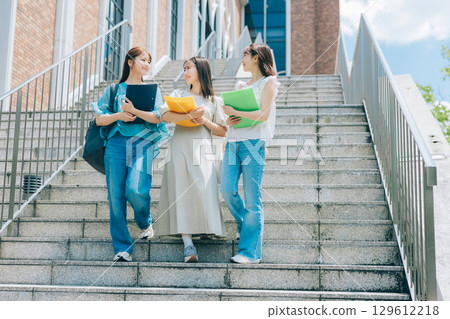 Three college students walking on campus Three college students walking on campus 129612218