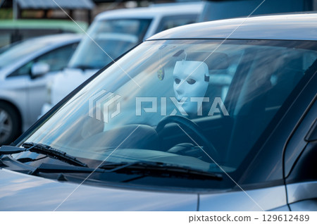 汽車後視鏡上掛著一個白色面具 129612489