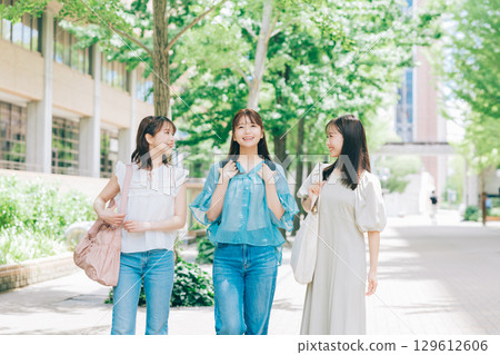 Three college students walking on campus 129612606