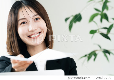 Business woman handing documents 129612709