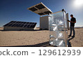 Engineer monitors a solar powered atmospheric water generator in a desert environment, utilizing renewable energy to extract potable water from the air 129612939