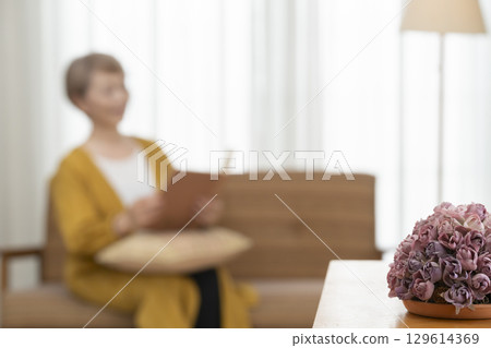 客廳沙發上看書的老年婦女 129614369