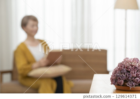 客廳沙發上看書的老年婦女 129614371