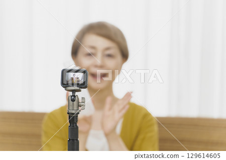 老年婦女在客廳觀看串流媒體視頻 129614605