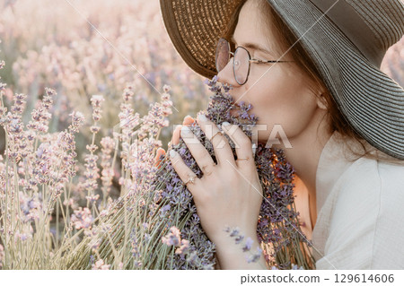 Woman In Lavender Field Enjoying The Aroma Of Flowers 129614606