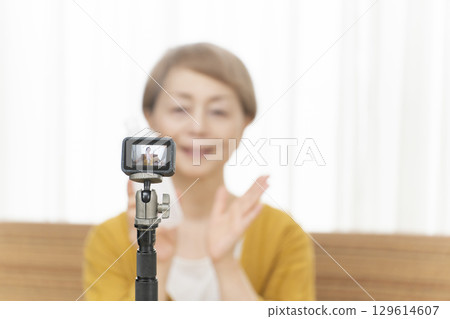 Senior woman streaming video in the living room Senior woman streaming video in the living room 129614607