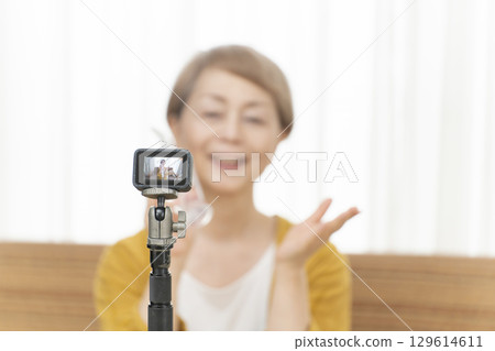 老年婦女在客廳觀看串流媒體視頻 老年婦女在客廳觀看串流媒體視頻 129614611