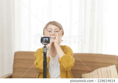 Senior woman streaming video in the living room Senior woman streaming video in the living room 129614614