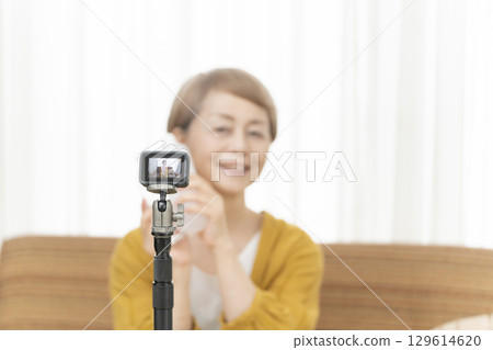 Senior woman streaming video in the living room Senior woman streaming video in the living room 129614620