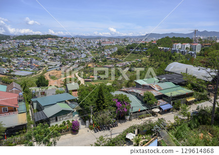 Aerial view of a city in a valley surrounded by forests with mountains on the horizon 129614868