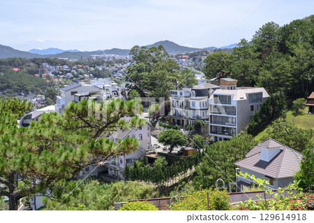 Aerial view of a city in a valley surrounded by forests with mountains on the horizon 129614918