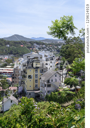 Aerial view of a city in a valley surrounded by forests with mountains on the horizon 129614919