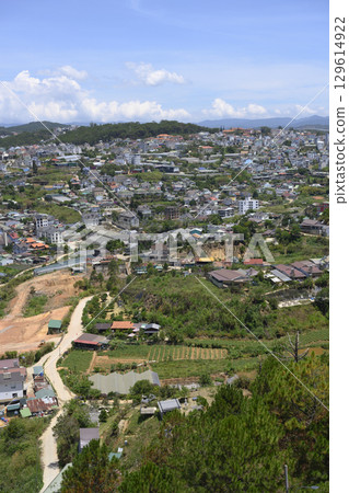 Aerial view of a city in a valley surrounded by forests with mountains on the horizon 129614922