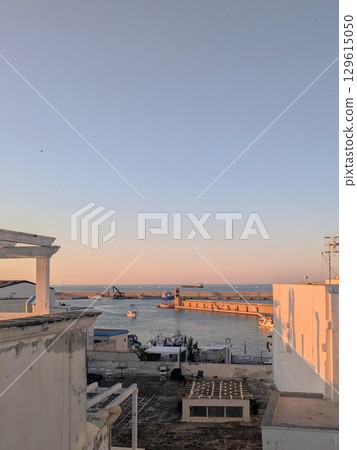 Port and breakwater in the setting sun | Cityscape of the Italian Mediterranean coast 129615050