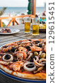 Delicious seafood pizza and beer enjoyed by the sea. 129615451