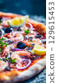 Delicious Seafood Pizza with Shrimp, Olives, and Lemon Slice. 129615453