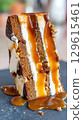 Decadent Caramel Drizzle on a Layered Cake Slice. 129615461