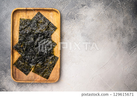 Crispy Nori seaweed sheets in a wooden tray. white background. top view 129615671