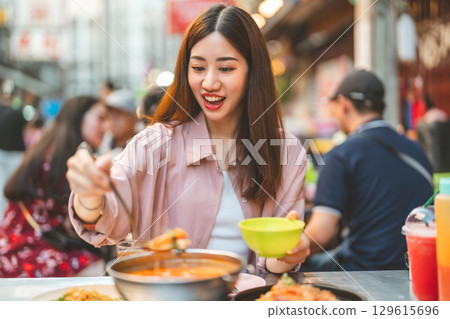 Traveler woman enjoy eating street food spicy thai tasty menu travel at chinatown Yaowarat, Bangkok, Thailand 129615696