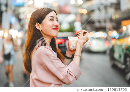Happy adult asian traveler woman eating sweet taiwan boba dessert menu at Yaowarat road 129615703