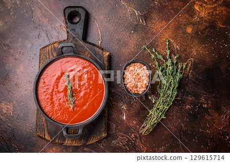Tomato sauce passata in a skillet , traditional recipe of italian cuisine. brown background. top view Tomato sauce passata in a skillet , traditional recipe of italian cuisine. brown background. top view 129615714