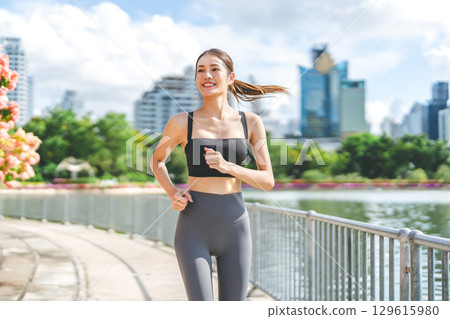 Southeast asian sport woman smiling running jogging at outdoors park exercise wear fitness outfit 129615980