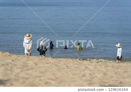 Family playing at the seaside 129616164