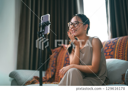 Asian woman influencer using smartphone wireless technology communication customer online marketing 129616178