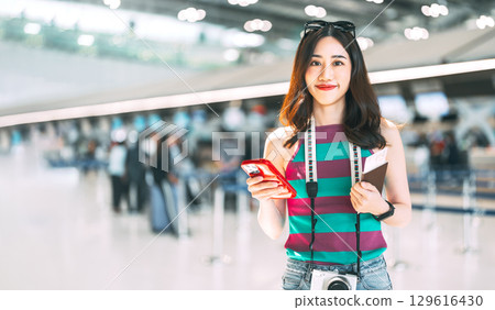 Portrait of tourist woman eye looking at camera with travel passport at airport terminal Portrait of tourist woman eye looking at camera with travel passport at airport terminal 129616430