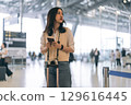 Portrait of standing tourist woman passenger at international airport terminal for holidays travel 129616445
