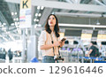 Portrait of standing tourist woman passenger at international airport terminal for holidays travel 129616446
