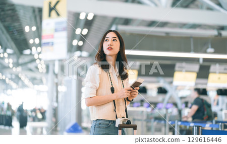 Portrait of standing tourist woman passenger at international airport terminal for holidays travel Portrait of standing tourist woman passenger at international airport terminal for holidays travel 129616446