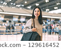 Portrait of standing tourist woman at international airport terminal for departure 129616452